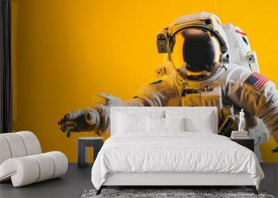 An astronaut in full gear stands with arm extended, evoking themes of space exploration and discovery on a vibrant yellow background Wall mural